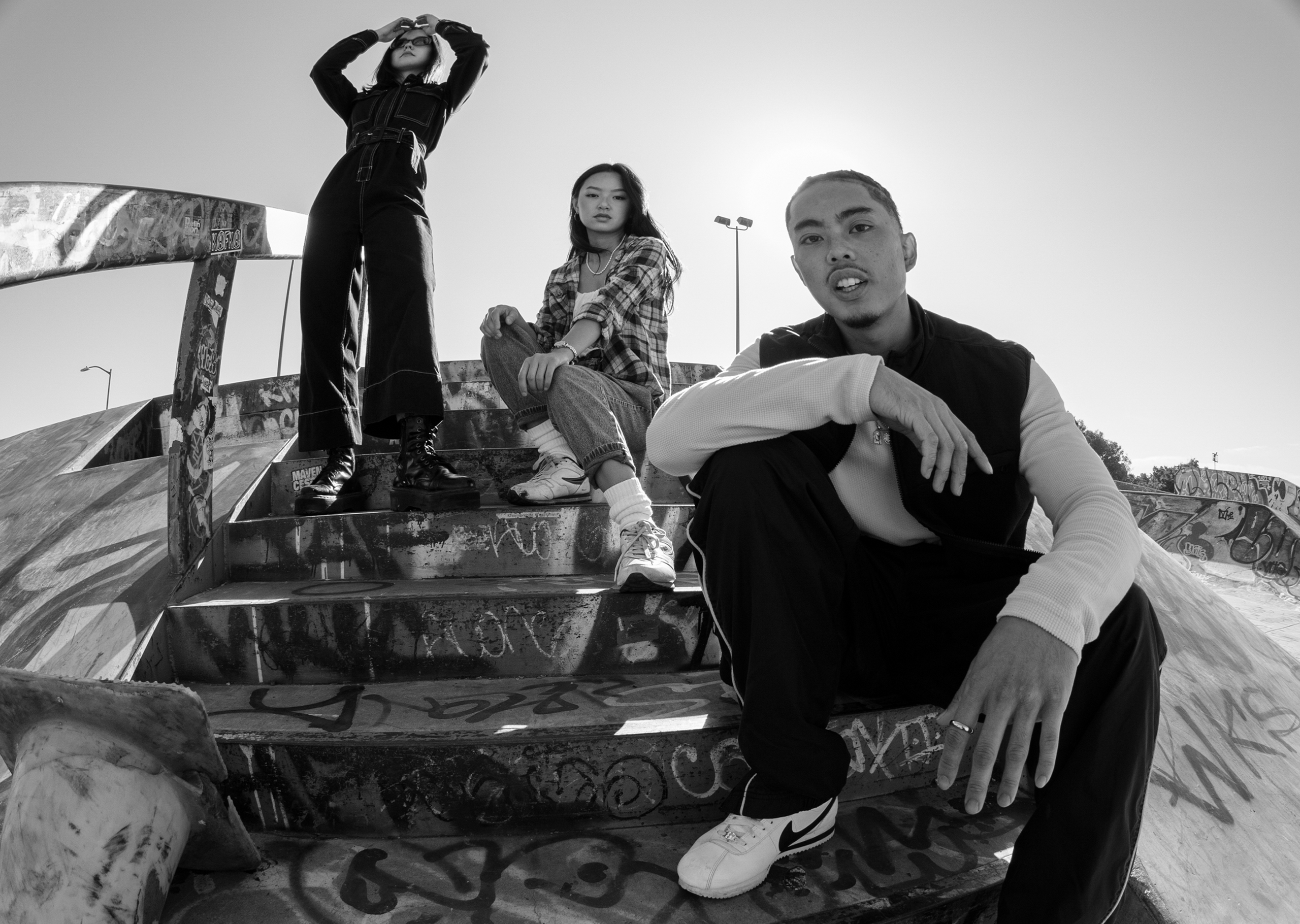 Three friends hanging out at a skate park